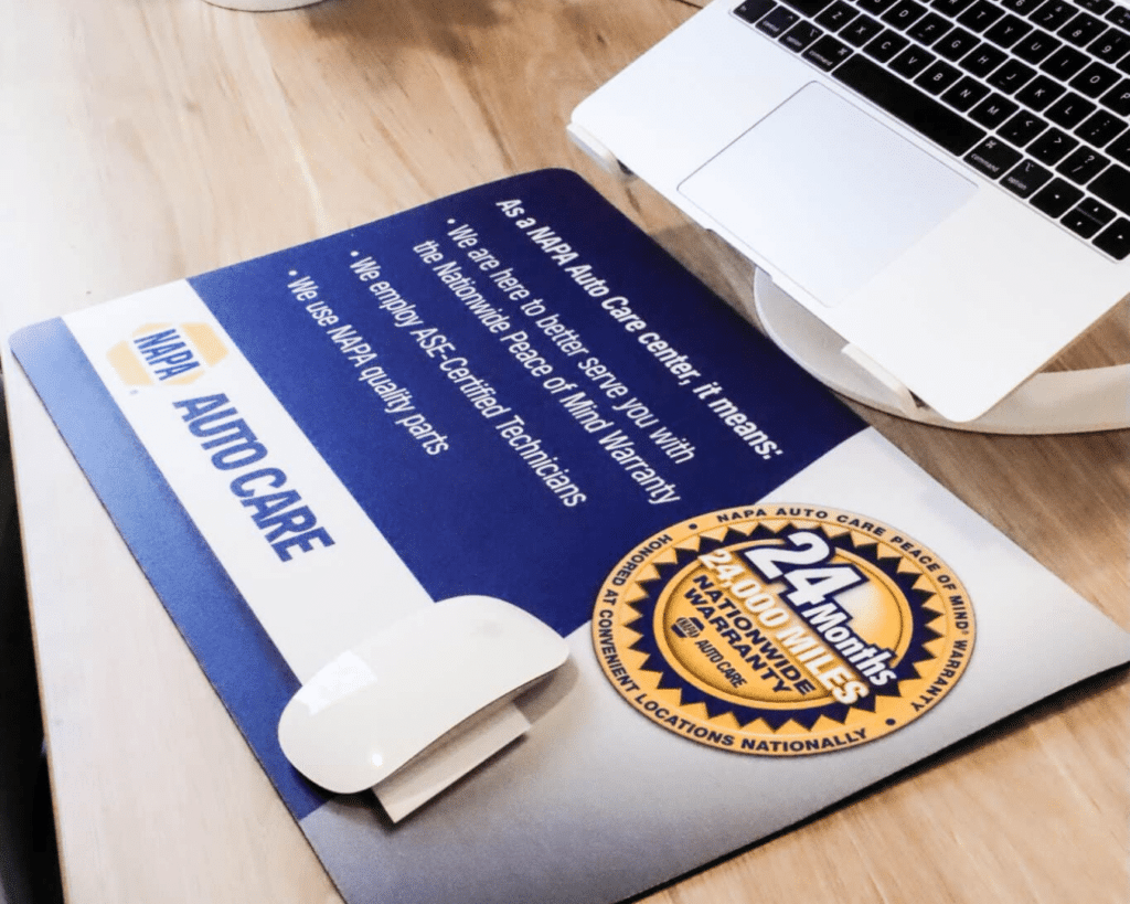 Photo of a custom counter mat by Countermats.net for a business on a desk with a computer.